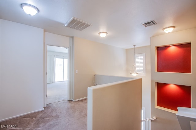 hall featuring an upstairs landing, visible vents, light carpet, and baseboards