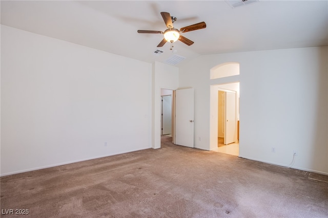 carpeted spare room with visible vents, lofted ceiling, and a ceiling fan