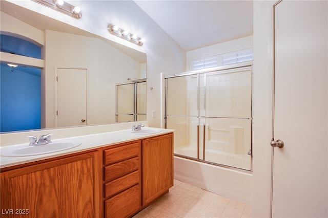 full bathroom with double vanity, combined bath / shower with glass door, and a sink