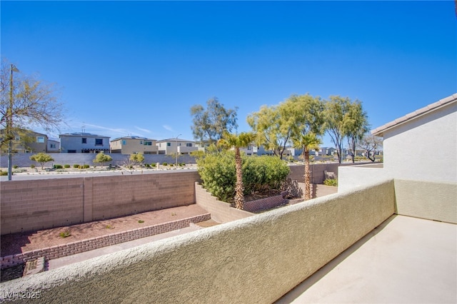 view of patio featuring a fenced backyard, a residential view, and a balcony