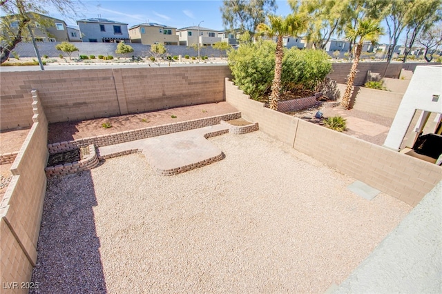 view of yard with a patio area, a fenced backyard, and a residential view