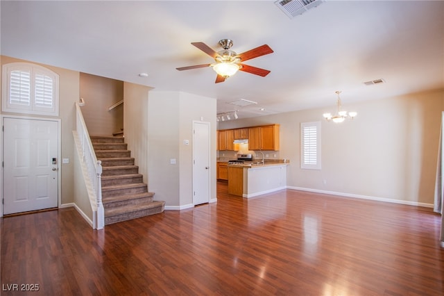 unfurnished living room featuring a sink, visible vents, dark wood finished floors, and stairway