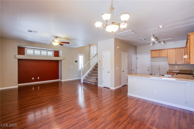 kitchen with visible vents, ceiling fan with notable chandelier, a peninsula, and dark wood-type flooring