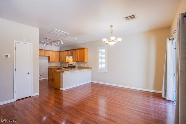 kitchen featuring a peninsula, open floor plan, visible vents, and dark wood-style flooring