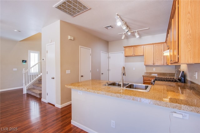 kitchen featuring a peninsula, visible vents, stainless steel range with gas cooktop, and a sink