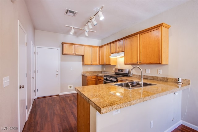 kitchen with visible vents, under cabinet range hood, a peninsula, stainless steel gas range, and a sink