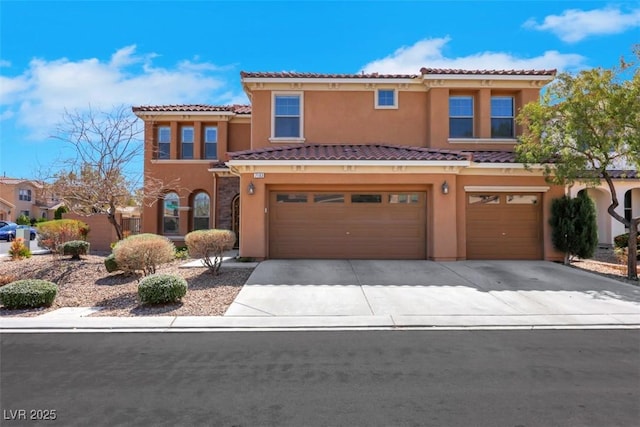 mediterranean / spanish-style home featuring a tiled roof, stucco siding, an attached garage, and concrete driveway