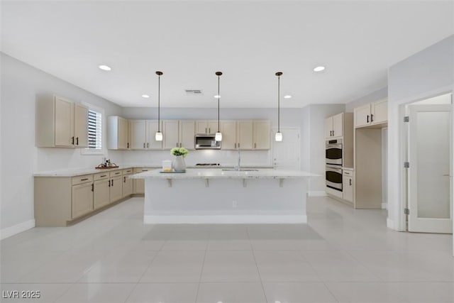 kitchen featuring visible vents, baseboards, recessed lighting, stainless steel appliances, and a kitchen island with sink