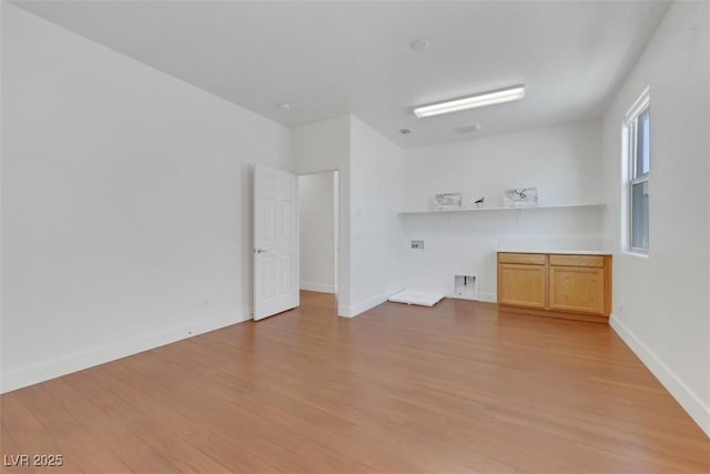 spare room featuring light wood-style flooring and baseboards