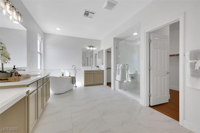 full bathroom featuring recessed lighting, a stall shower, a freestanding tub, marble finish floor, and vanity