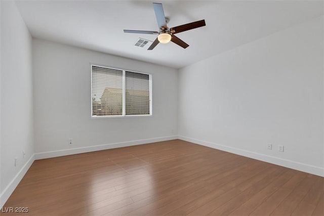 unfurnished room with visible vents, baseboards, ceiling fan, and wood finished floors