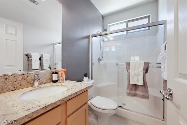 full bathroom with vanity, visible vents, tile patterned flooring, a shower stall, and toilet