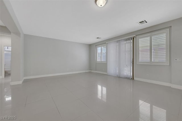 unfurnished room featuring light tile patterned floors and baseboards