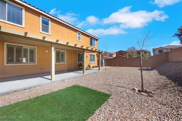 back of property featuring stucco siding, a patio, a fenced backyard, and a tiled roof