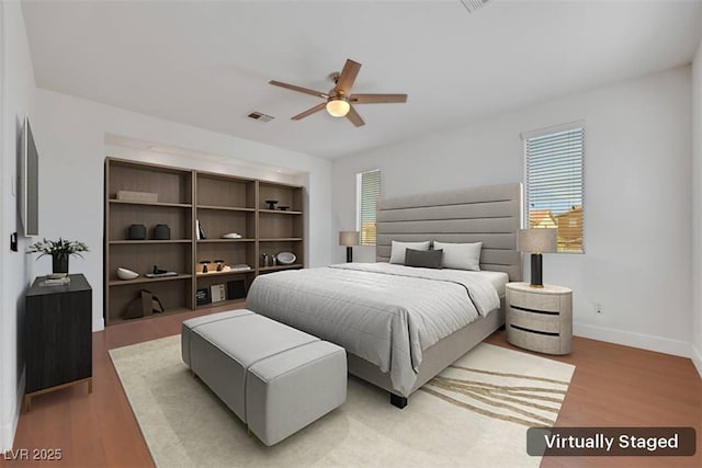 bedroom with light wood finished floors, visible vents, ceiling fan, and baseboards