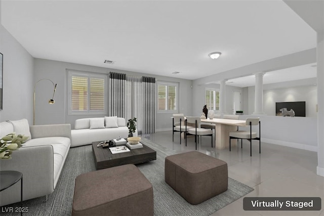 living room featuring visible vents, baseboards, and ornate columns