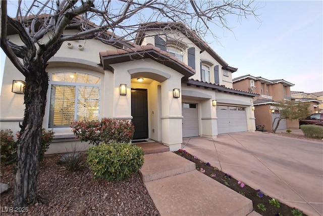 mediterranean / spanish house with concrete driveway, a garage, and stucco siding