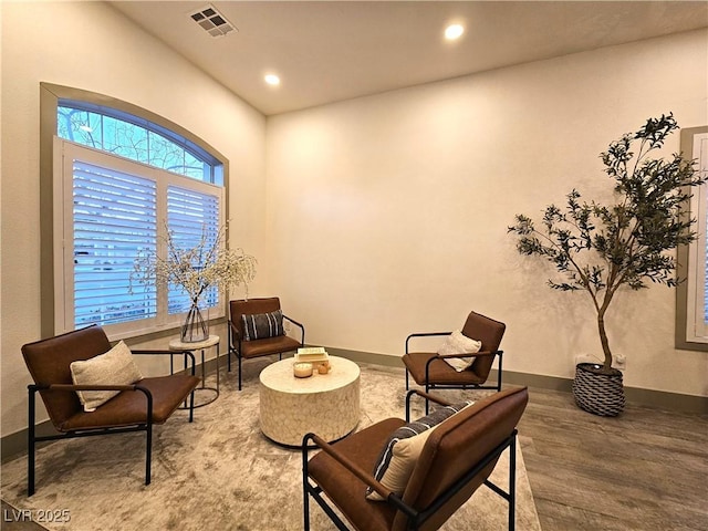 living area featuring recessed lighting, visible vents, baseboards, and wood finished floors