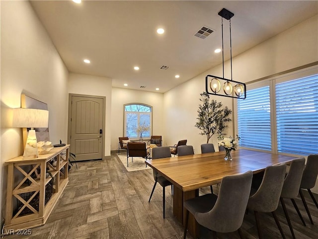 dining space with recessed lighting, visible vents, and parquet floors