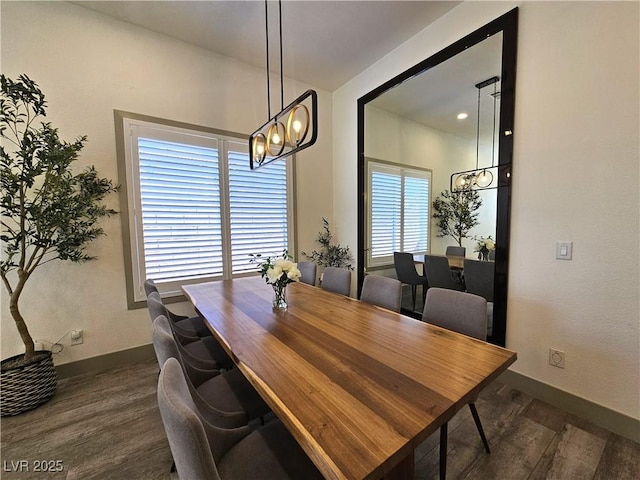 dining area with baseboards, a notable chandelier, and dark wood-style flooring