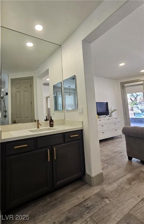 bathroom with recessed lighting, vanity, and wood finished floors