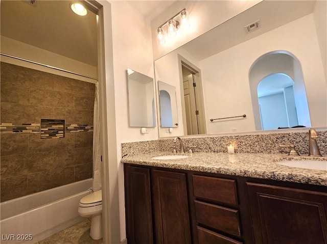 full bathroom with double vanity, visible vents, toilet, and a sink