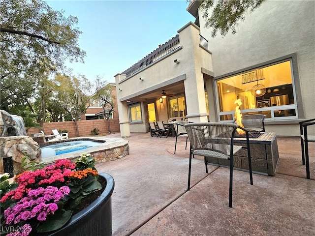 view of patio with a hot tub and fence