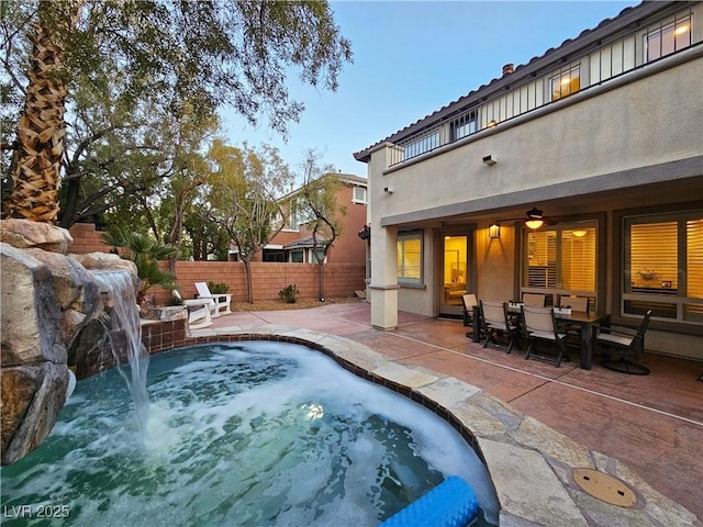 view of swimming pool featuring a patio area, a jacuzzi, and fence