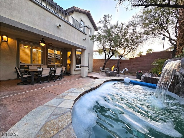 view of swimming pool featuring outdoor dining space, a patio area, fence, and ceiling fan