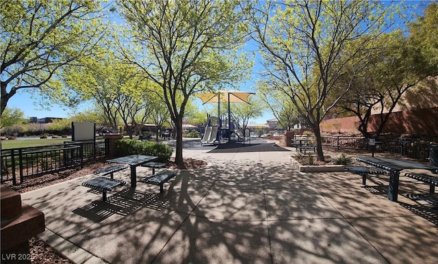 view of home's community featuring playground community and fence