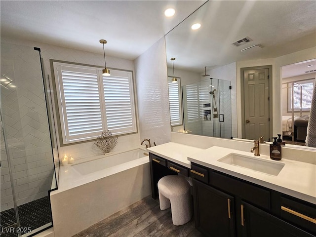 full bathroom with vanity, wood finished floors, visible vents, a shower stall, and a bath