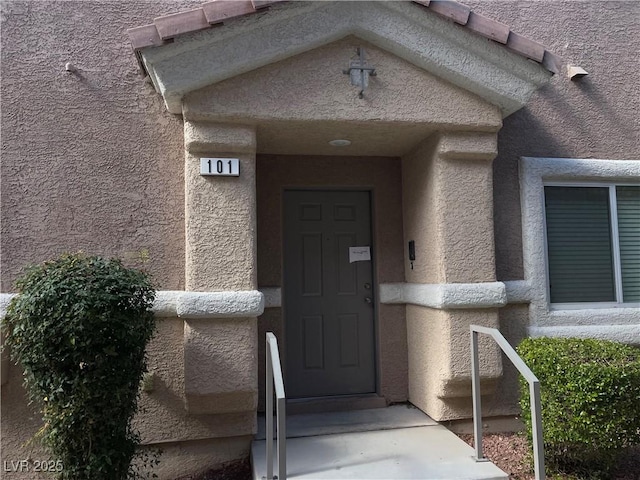 property entrance with stucco siding