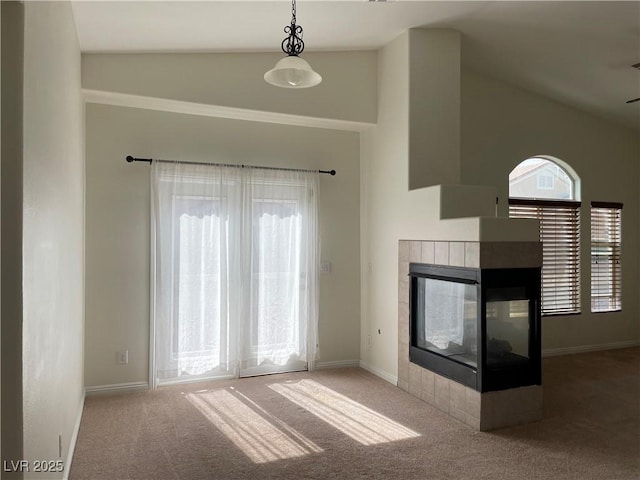 unfurnished living room with high vaulted ceiling, carpet, baseboards, and a tile fireplace