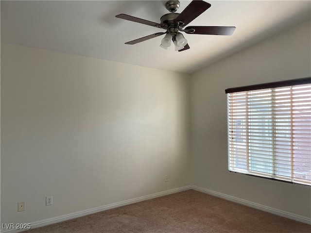 carpeted spare room featuring vaulted ceiling, baseboards, and ceiling fan