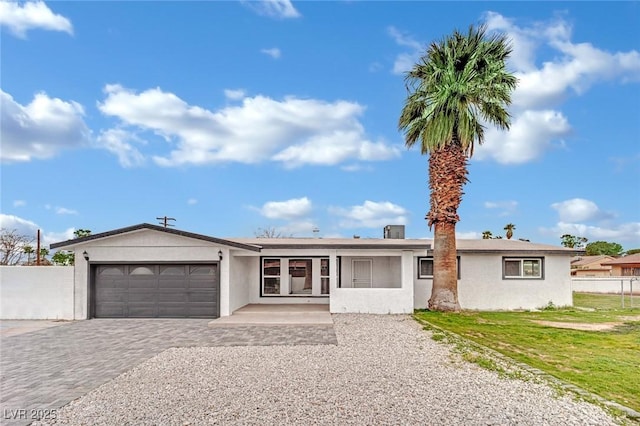 ranch-style house with stucco siding, decorative driveway, an attached garage, and fence