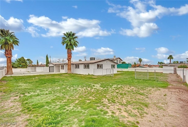 rear view of house with a yard and a fenced backyard