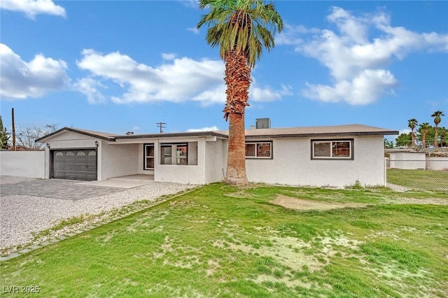 view of front of property with stucco siding, an attached garage, driveway, and fence