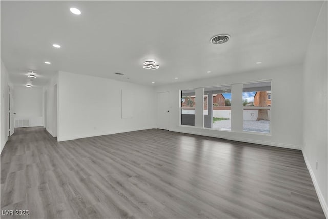 unfurnished living room featuring recessed lighting, wood finished floors, visible vents, and baseboards