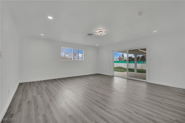 unfurnished room with recessed lighting, wood finished floors, and baseboards