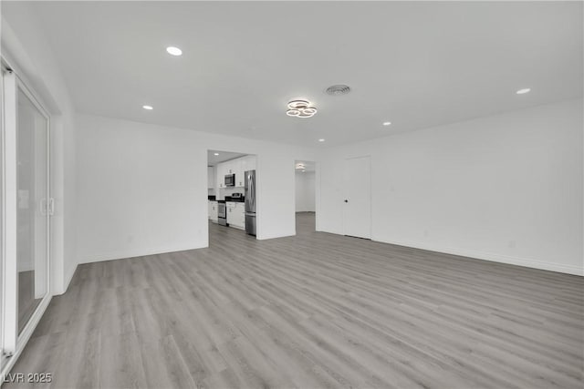 unfurnished living room with visible vents, recessed lighting, light wood-type flooring, and baseboards