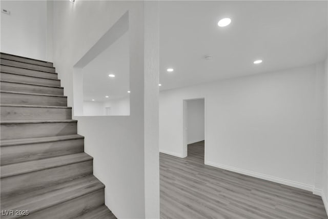 stairway with recessed lighting, baseboards, and wood finished floors