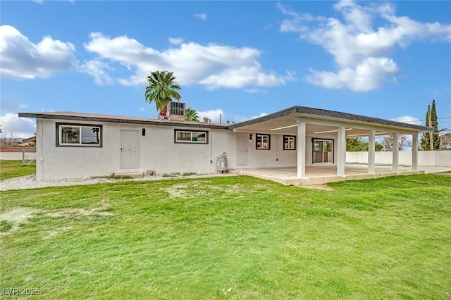 back of property featuring stucco siding, a lawn, cooling unit, and a patio area