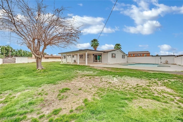 rear view of house featuring a patio, a yard, a fenced in pool, and fence