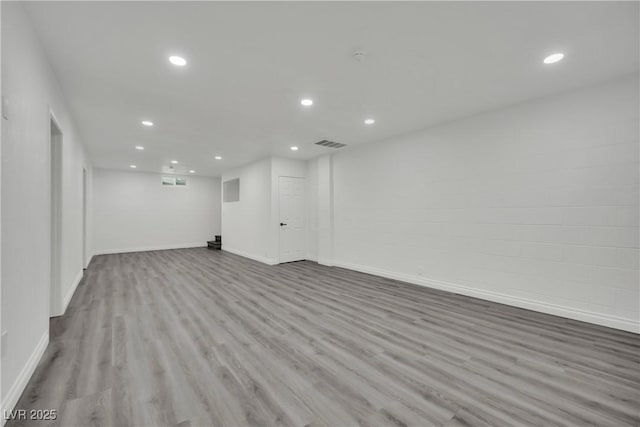 finished basement with recessed lighting, wood finished floors, visible vents, and baseboards