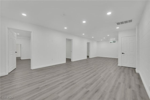 basement with light wood-style flooring, recessed lighting, visible vents, and baseboards