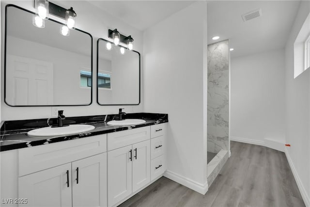 full bathroom with visible vents, wood finished floors, and a sink