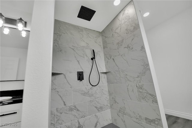 full bathroom with vanity, wood finished floors, and a tile shower