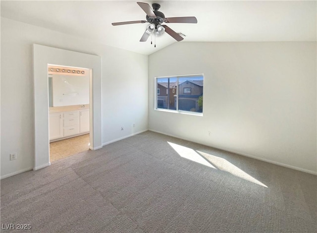 carpeted empty room with baseboards, lofted ceiling, visible vents, and a ceiling fan