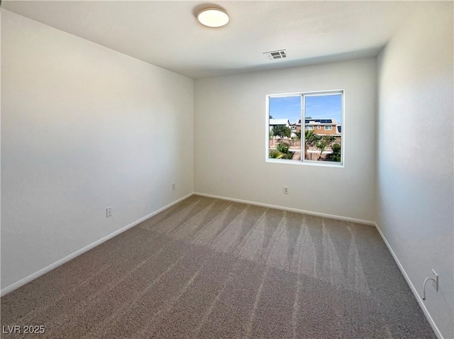 carpeted spare room with visible vents and baseboards