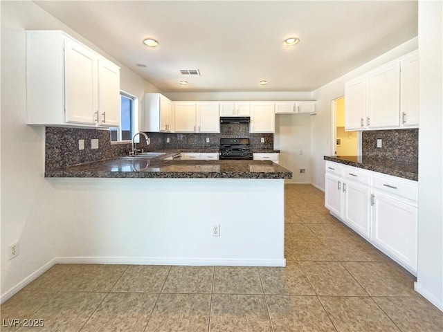 kitchen featuring visible vents, under cabinet range hood, a peninsula, gas stove, and a sink